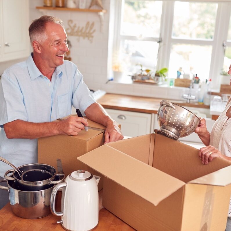 Mature couple packing away boxes